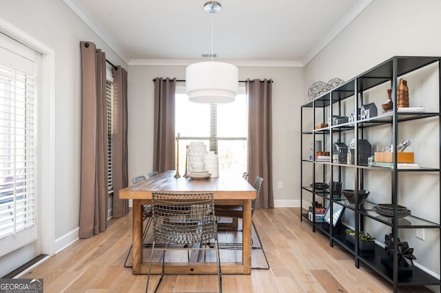 dining area featuring baseboards, crown molding, and light wood-style floors
