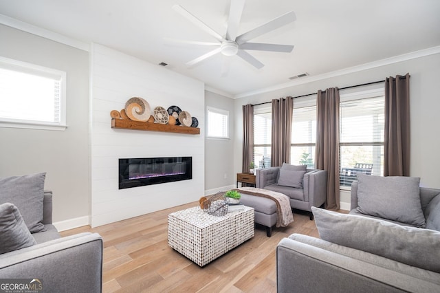 living room with a ceiling fan, crown molding, light wood-style floors, a fireplace, and visible vents