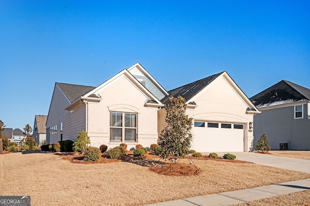 single story home with cooling unit, brick siding, driveway, and a garage