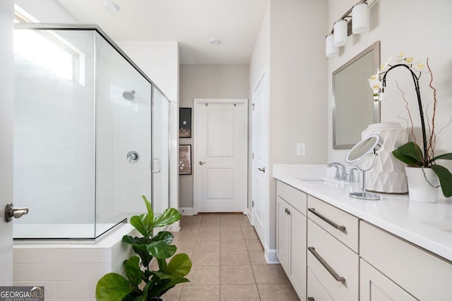 bathroom featuring a sink, tile patterned flooring, a shower stall, and double vanity