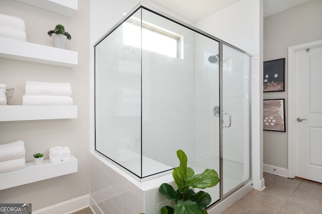 bathroom with a shower with door and tile patterned floors