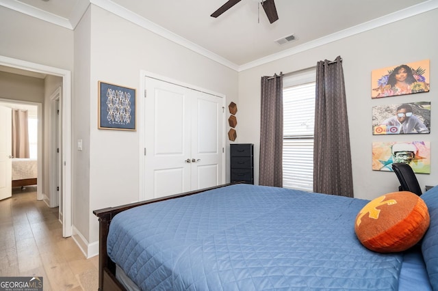 bedroom with crown molding, a closet, ceiling fan, and light wood-type flooring