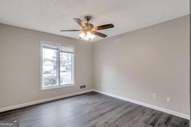 empty room with ceiling fan and dark hardwood / wood-style floors