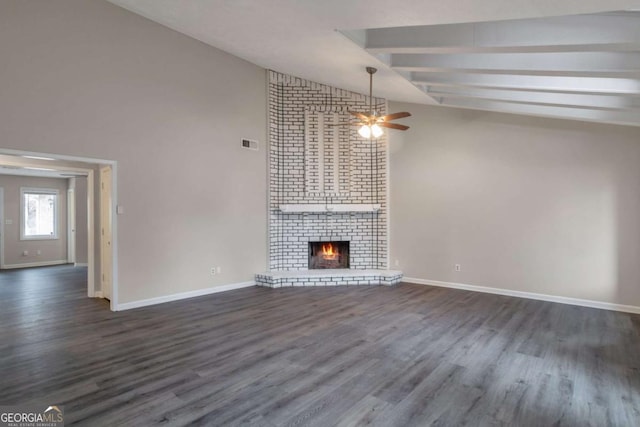 unfurnished living room featuring ceiling fan, dark hardwood / wood-style floors, vaulted ceiling with beams, and a fireplace