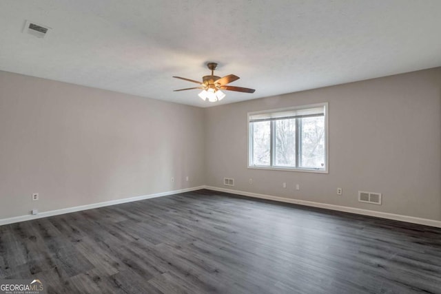 spare room featuring dark hardwood / wood-style flooring and ceiling fan