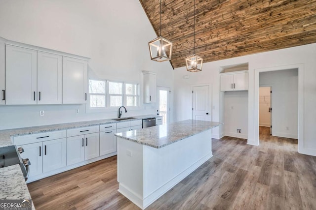 kitchen with white cabinetry, decorative light fixtures, and high vaulted ceiling