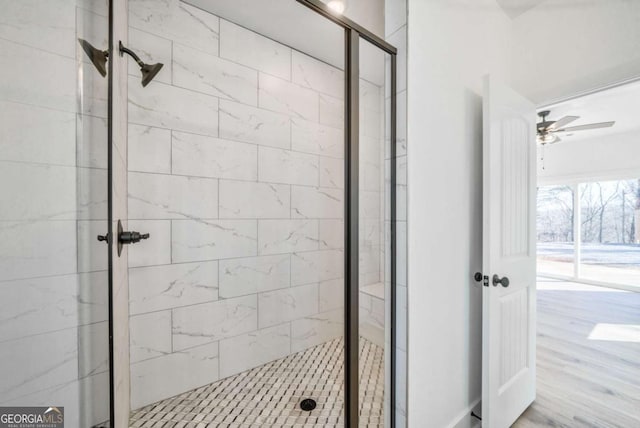 bathroom featuring wood-type flooring, ceiling fan, and a shower with shower door