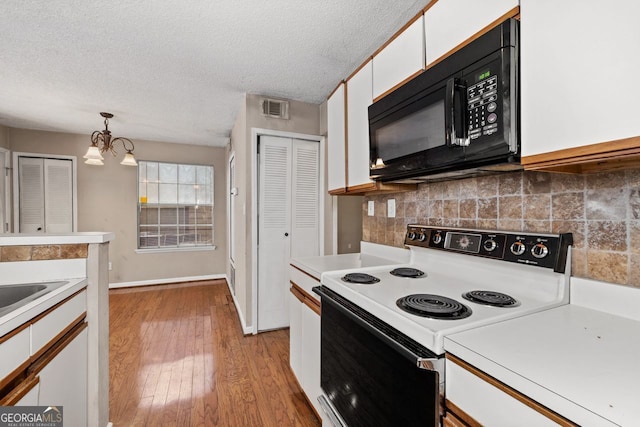 kitchen with light hardwood / wood-style flooring, hanging light fixtures, white cabinets, white range with electric cooktop, and backsplash