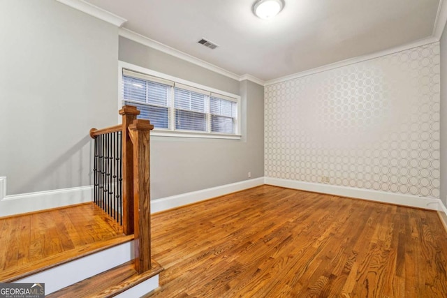 empty room featuring crown molding and hardwood / wood-style floors