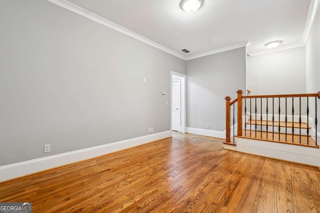 empty room featuring crown molding and hardwood / wood-style floors