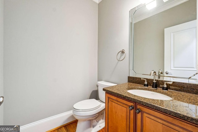 bathroom featuring vanity, wood-type flooring, and toilet