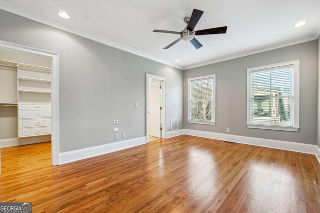 unfurnished bedroom with ornamental molding, light wood-type flooring, ceiling fan, and a closet