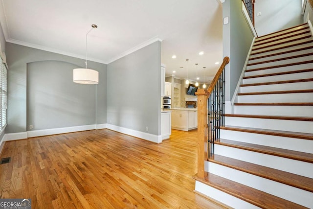 interior space with ornamental molding and light hardwood / wood-style flooring