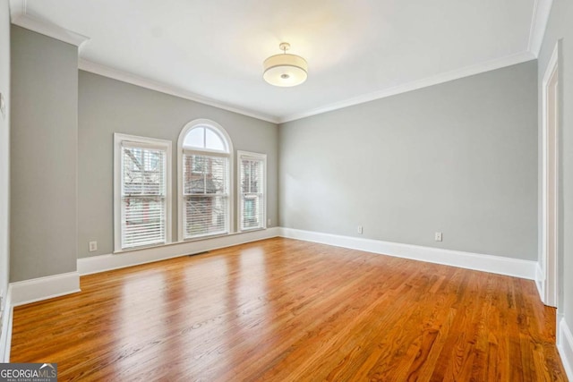 spare room with crown molding and wood-type flooring