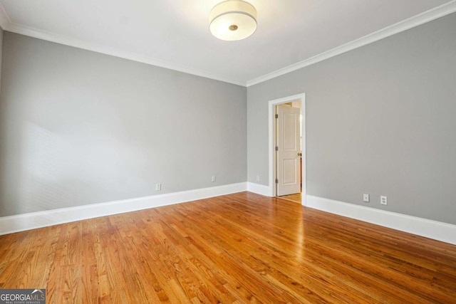 unfurnished room featuring ornamental molding and wood-type flooring