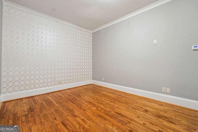 empty room featuring ornamental molding and hardwood / wood-style floors