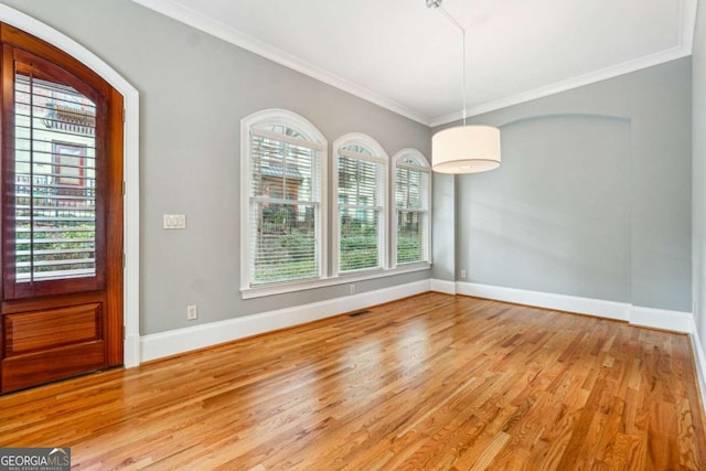 entryway with crown molding and light hardwood / wood-style floors