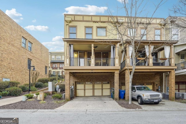 view of property with a garage, a balcony, and ceiling fan