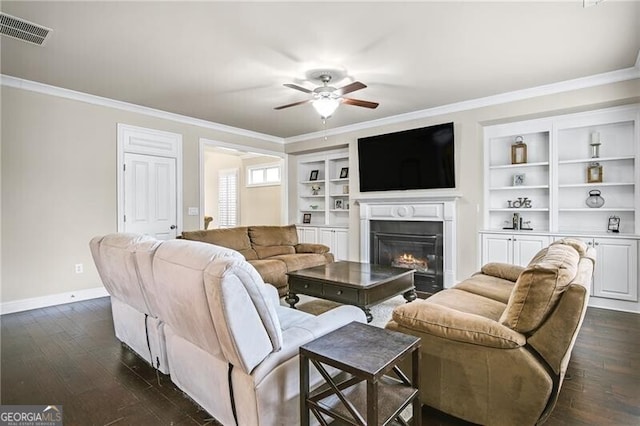 living room with crown molding, ceiling fan, dark hardwood / wood-style flooring, and built in features