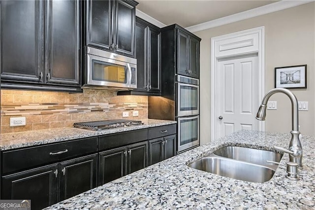 kitchen featuring appliances with stainless steel finishes, sink, decorative backsplash, light stone counters, and crown molding