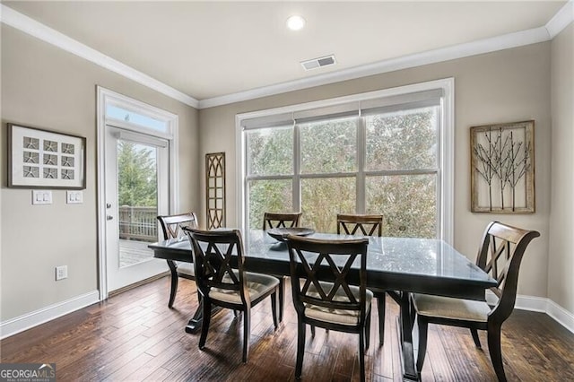 dining space featuring dark hardwood / wood-style flooring and crown molding