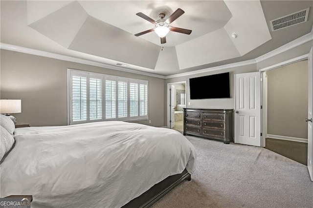 bedroom with crown molding, a tray ceiling, light colored carpet, and ceiling fan