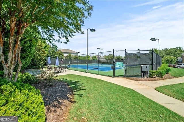 view of sport court with a lawn