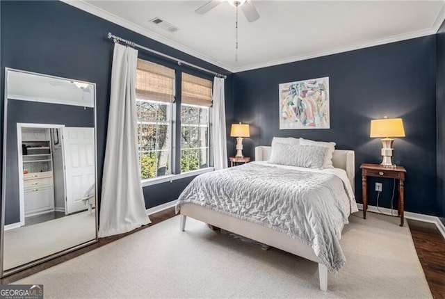 bedroom featuring wood-type flooring, ornamental molding, and ceiling fan