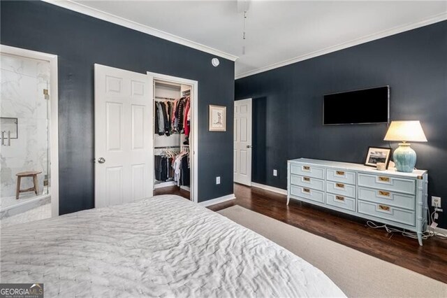 bedroom featuring crown molding, a walk in closet, a closet, and dark wood-type flooring