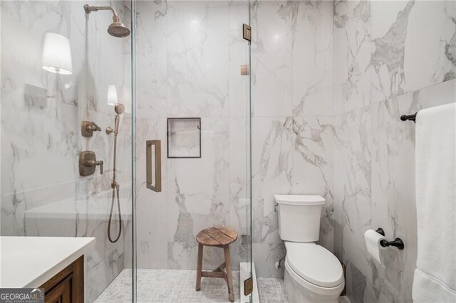 bathroom with walk in shower, vanity, and toilet