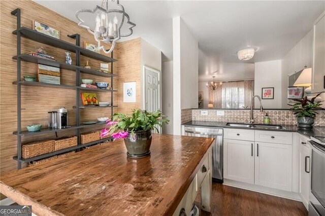 kitchen featuring white cabinetry, appliances with stainless steel finishes, dark wood-type flooring, and a notable chandelier