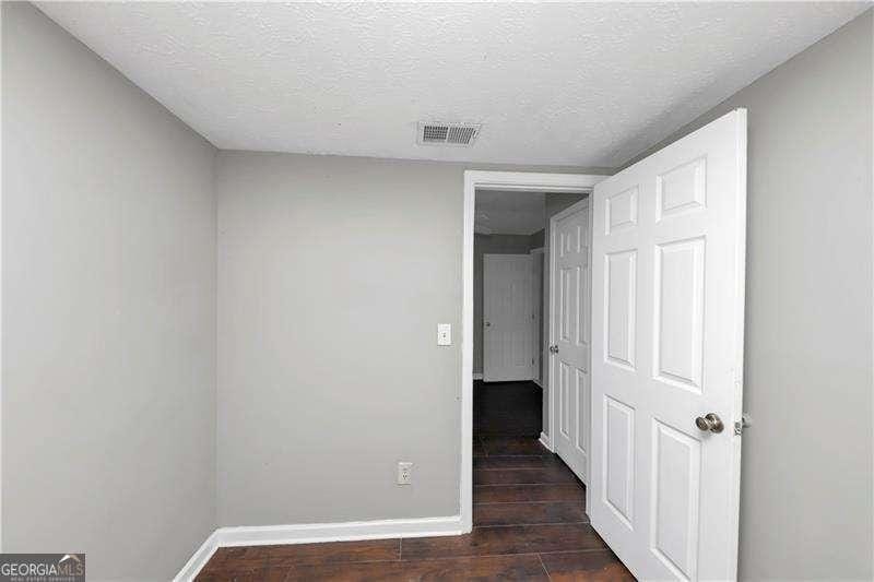 unfurnished bedroom featuring dark hardwood / wood-style flooring and a textured ceiling