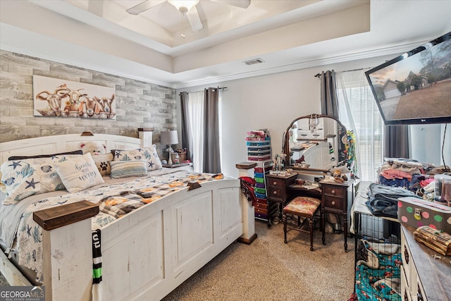 bedroom featuring ceiling fan, a tray ceiling, and light colored carpet