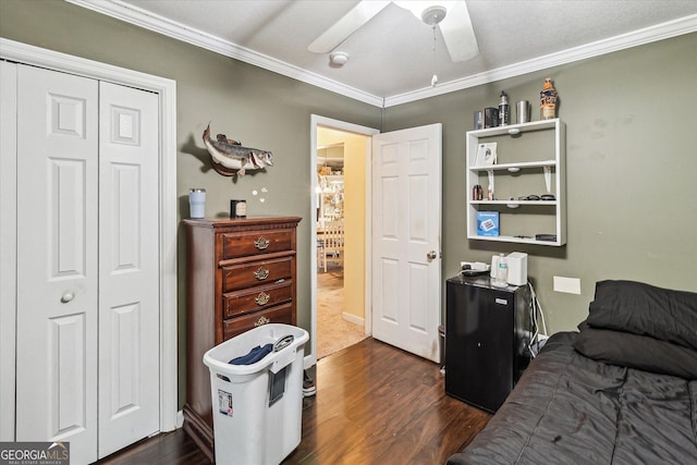 bedroom with ornamental molding, dark hardwood / wood-style floors, ceiling fan, and a closet