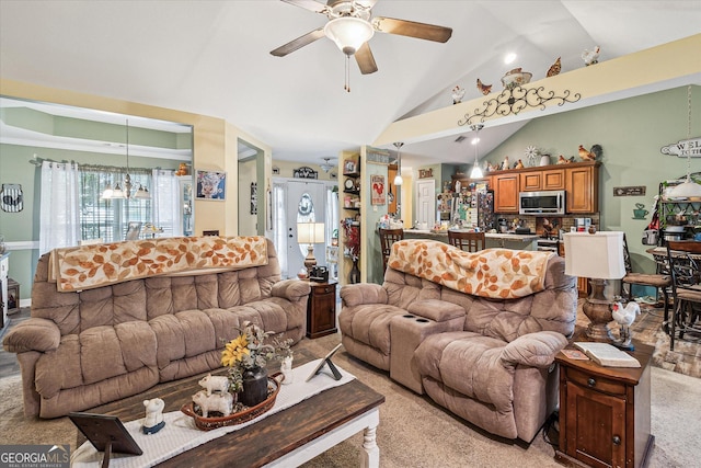 living room featuring lofted ceiling, ceiling fan with notable chandelier, and light colored carpet