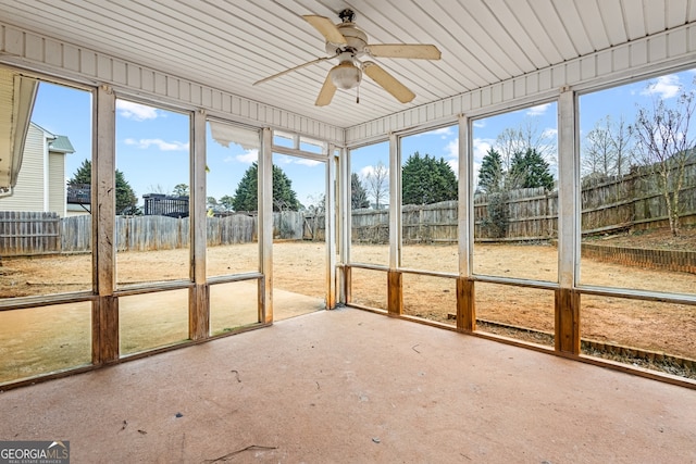 unfurnished sunroom featuring ceiling fan