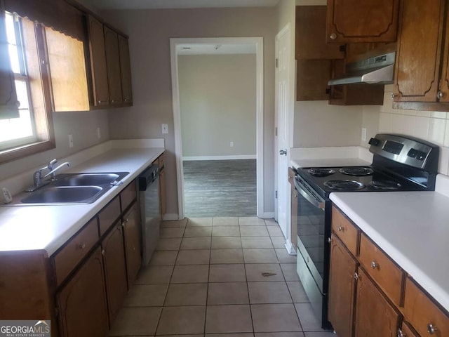 kitchen featuring stainless steel appliances, light tile patterned flooring, and sink