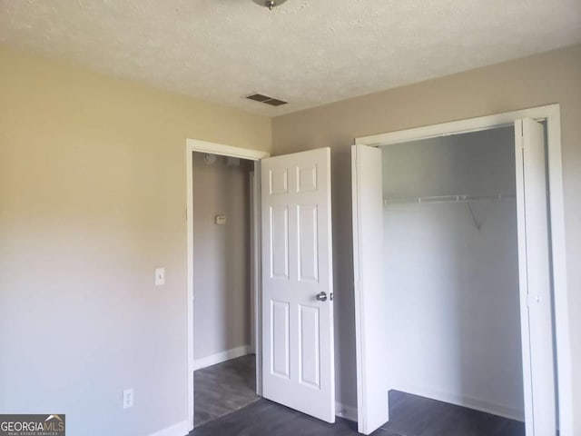 unfurnished bedroom with a textured ceiling and a closet