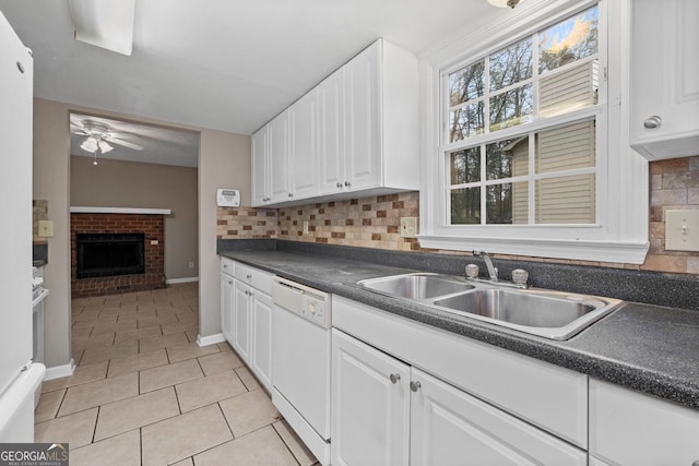 kitchen featuring sink, white cabinetry, white dishwasher, light tile patterned flooring, and decorative backsplash