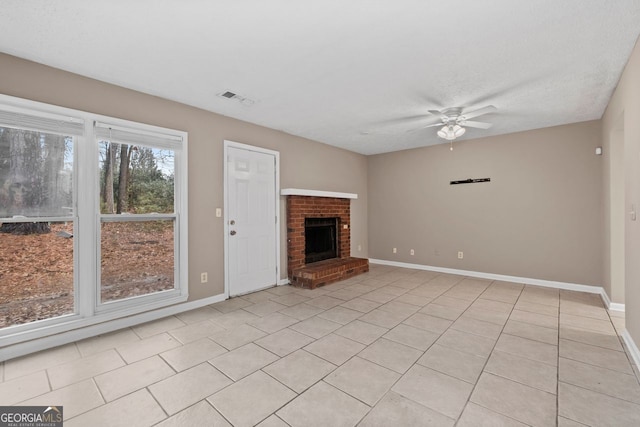 unfurnished living room with light tile patterned floors, a textured ceiling, a fireplace, and ceiling fan