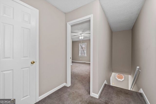 hallway featuring carpet and a textured ceiling