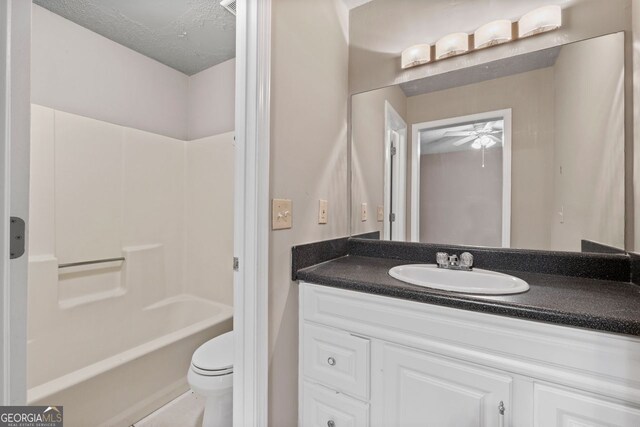 full bathroom with vanity, toilet, bathing tub / shower combination, and a textured ceiling