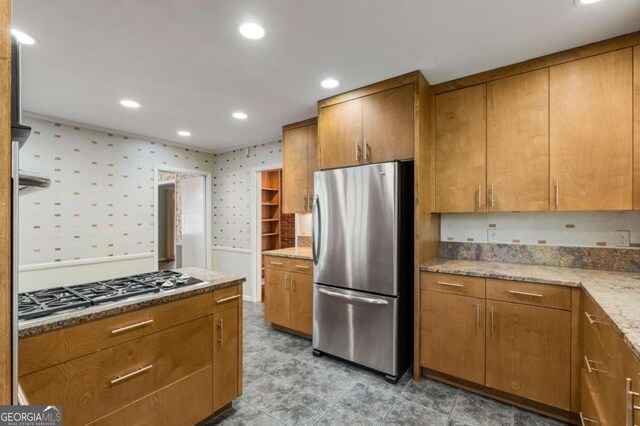 kitchen with light stone countertops and appliances with stainless steel finishes