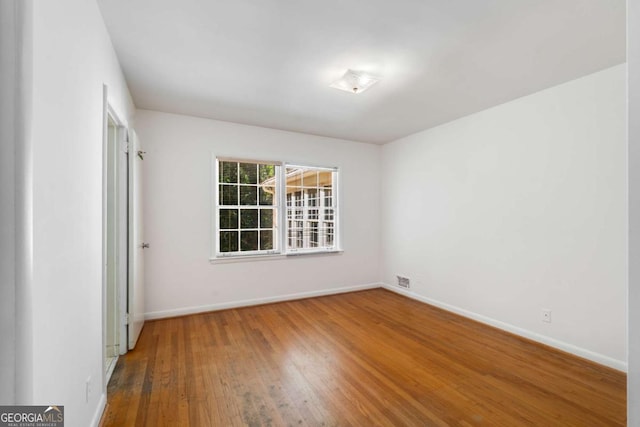 unfurnished room with wood-type flooring