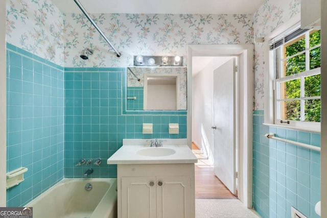 bathroom featuring washtub / shower combination, vanity, and tile walls