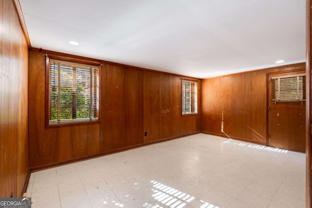 unfurnished room with crown molding and wood walls