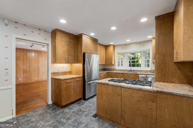 kitchen with light stone counters, stainless steel appliances, and sink