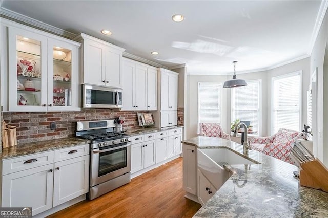 kitchen with tasteful backsplash, stone countertops, appliances with stainless steel finishes, pendant lighting, and white cabinets