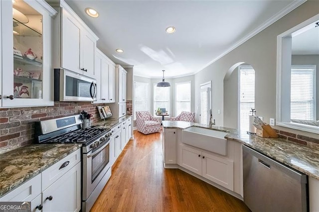 kitchen with stainless steel appliances, sink, white cabinets, and decorative backsplash