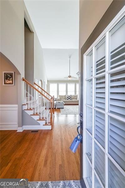 foyer entrance featuring hardwood / wood-style flooring, ceiling fan, and vaulted ceiling